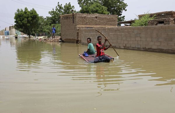 Thiếu niên chống bè bơi trên đường phố ngập lụt ở Salmaniya, Sudan - Sputnik Việt Nam