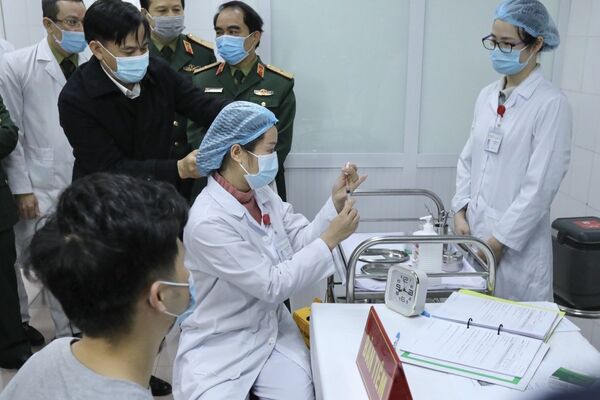 Bác sĩ chuẩn bị tiêm mũi vaccine Nanocovax ngừa COVID-19 đầu tiên cho tình nguyện viên. Đây là vaccine đầu tiên của Việt Nam được đưa vào thử nghiệm lâm sàng - Sputnik Việt Nam