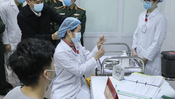 Bác sĩ chuẩn bị tiêm mũi vaccine Nanocovax ngừa COVID-19 đầu tiên cho tình nguyện viên. Đây là vaccine đầu tiên của Việt Nam được đưa vào thử nghiệm lâm sàng. - Sputnik Việt Nam