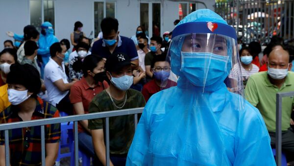 Nhân viên y tế mặc đồ bảo hộ và người xếp hàng tại Trung tâm xét nghiệm coronavirus ở Hà Nội. - Sputnik Việt Nam