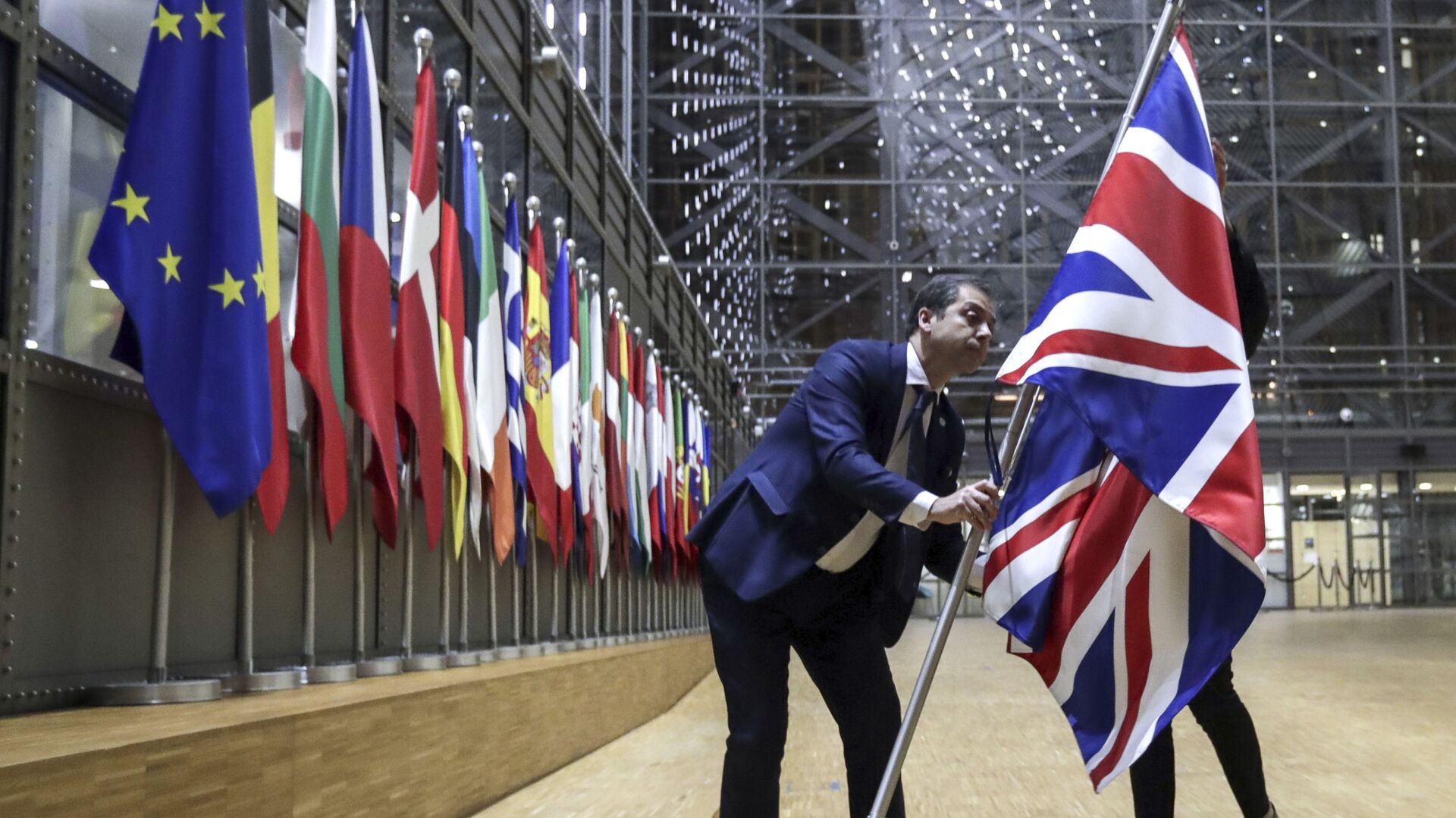 Nhân viên bộ phận nghị định gỡ bỏ cờ Vương quốc Anh khỏi tòa nhà Châu Âu ở Brussels. - Sputnik Việt Nam, 1920, 04.06.2021