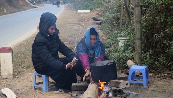Người dân sinh sống dưới chân đèo Pha Đin, cạnh QL6 đốt lửa sưởi ấm, chống chọi với giá lạnh. - Sputnik Việt Nam