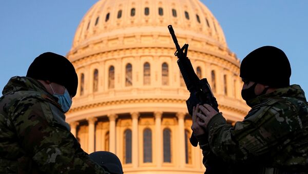 Một thành viên của Lực lượng Vệ binh Quốc gia Hoa Kỳ nhận vũ khí bên ngoài tòa nhà Capitol ở Washington DC - Sputnik Việt Nam