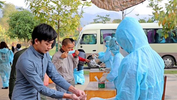 Công dân về từ Pháp rửa tay sát khuẩn tại khu cách ly tập trung. - Sputnik Việt Nam