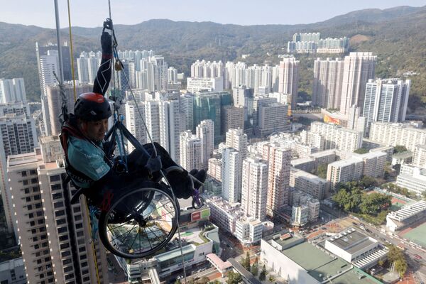 Nhà leo núi bị liệt chi dưới Lai Chi-Wai cố gắng leo lên Tháp Nina ở Hồng Kông - Sputnik Việt Nam