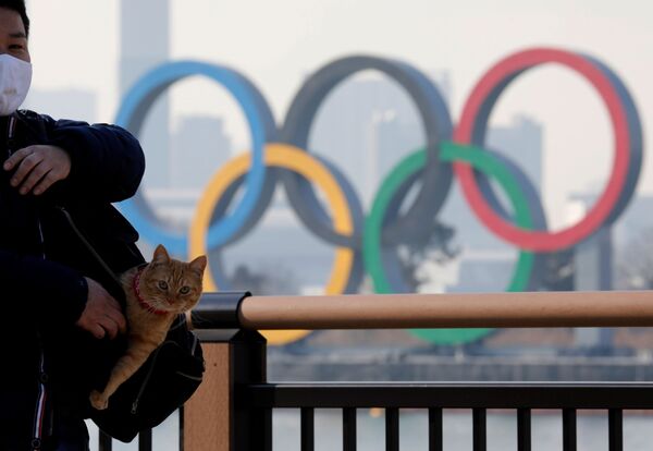 Người đàn ông với con mèo trong túi trên nền biểu tượng Olympic ở Tokyo - Sputnik Việt Nam