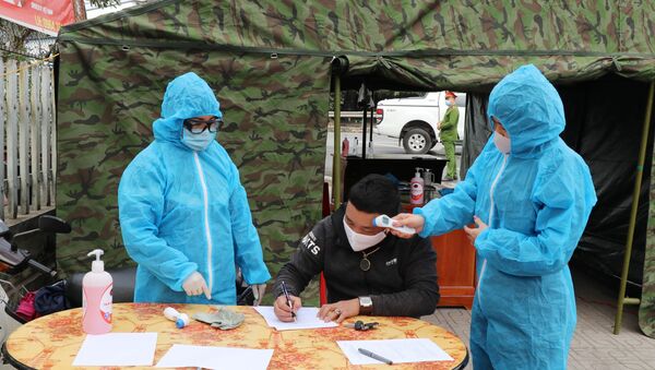 Nhân viên y tế hướng dẫn lái xe ngoại tỉnh khai báo y tế và kiểm tra thân nhiệt tại chốt kiểm tra liên ngành nút giao Thịnh Đán, Thành phố Thái Nguyên  - Sputnik Việt Nam