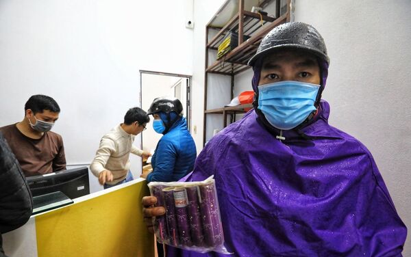 Người dân Thủ đô đội mưa đến mua pháo hoa không nổ tại Cửa hàng giới thiệu sản phẩm Công ty TNHH MTV Hóa chất 21 (số 67 Lạc Trung, Hà Nội) - Sputnik Việt Nam