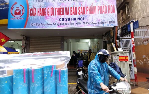 Người dân Thủ đô đội mưa đến mua pháo hoa không nổ tại Cửa hàng giới thiệu sản phẩm Công ty TNHH MTV Hóa chất 21 (số 67 Lạc Trung, Hà Nội). - Sputnik Việt Nam