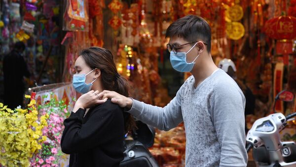 Cặp đôi đeo khẩu trang đi dạo trên phố Hà Nội.  - Sputnik Việt Nam