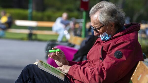 Người đàn ông lớn tuổi đeo khẩu trang khi nghỉ ngơi trong công viên ở Vienna. - Sputnik Việt Nam