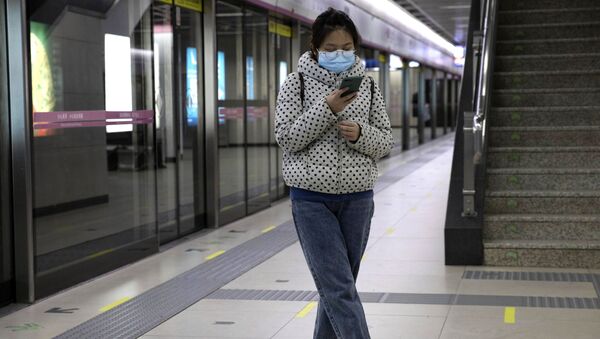 Cô gái với chiếc điện thoại thông minh ở ga tàu điện ngầm Vũ Hán. - Sputnik Việt Nam