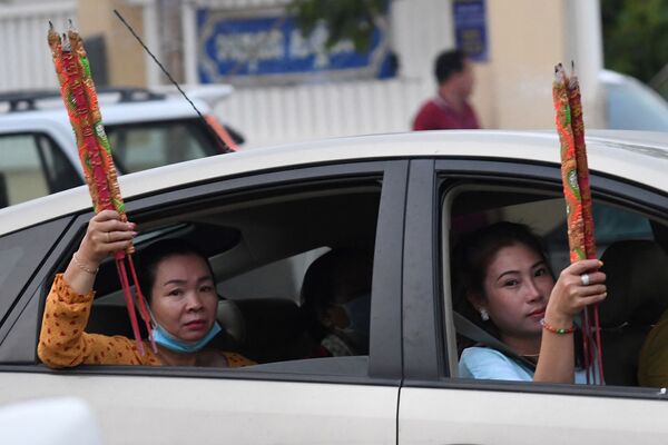 Hai người phụ nữ cầm thẻ hương ngồi trong xe ô tô, chuẩn bị đón Tết Nguyên đán ở Takmau, Campuchia - Sputnik Việt Nam