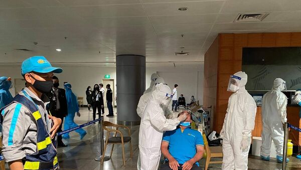 Nhân viên y tế lấy mẫu xét nghiệm cho người làm việc tại sân bay Tân Sơn Nhất ngày 6/2. - Sputnik Việt Nam