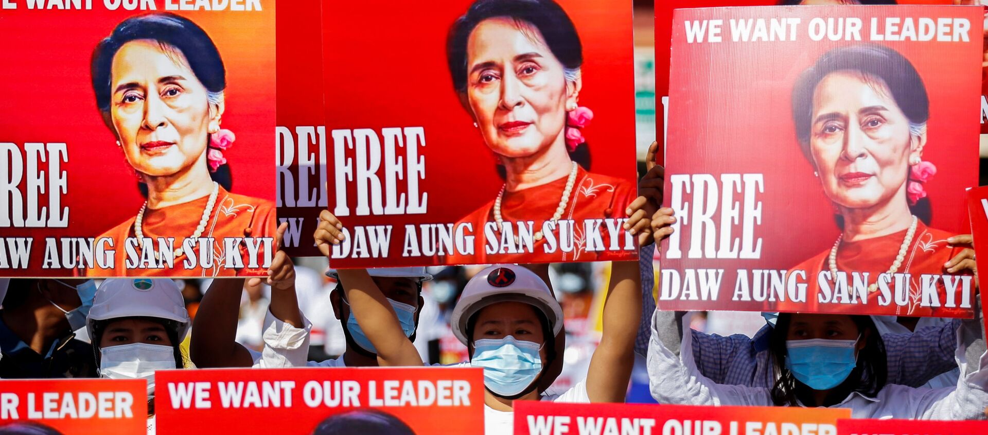 Người biểu tình mang áp phích in hình bà Aung San Suu Kyi ở Myanmar. - Sputnik Việt Nam, 1920, 16.02.2021