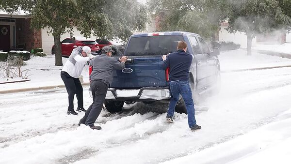 Người dân giúp một người lái xe bán tải thoát khỏi băng trên đường ở Round Rock, Texas, vào ngày 17 tháng 2 năm 2021, sau một cơn bão mùa đông - Sputnik Việt Nam