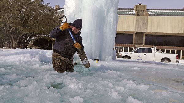 Một công nhân phá băng trong một đài phun nước đóng băng ở Richardson, Texas, Mỹ - Sputnik Việt Nam