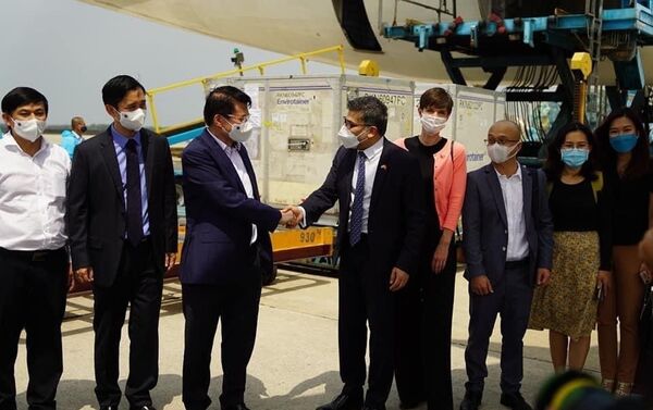 Thứ trưởng Bộ Y tế Trương Quốc Cường tiếp nhận lô vắc xin COVID-19 đầu tiên của AstraZeneca về đến Việt Nam.  - Sputnik Việt Nam