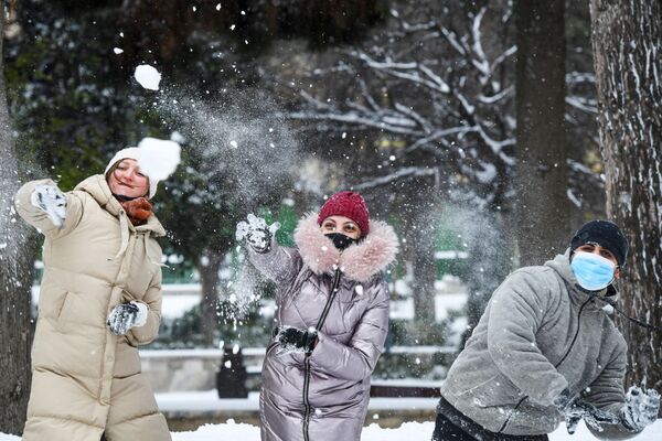 Khách bộ hành chơi ném tuyết trên đường phố ở Baku trong trận tuyết rơi - Sputnik Việt Nam