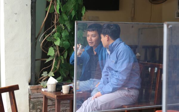Một cửa hàng cafe trên phố Hàng Chuối trang bị tấm chắn phục vụ giãn cách cho khách.  - Sputnik Việt Nam