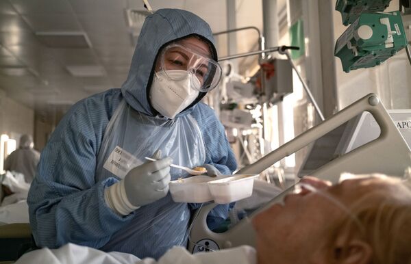 Nữ y tá cho bệnh nhân ăn trong phòng chăm sóc đặc biệt tại bệnh viện ở Moskva - Sputnik Việt Nam