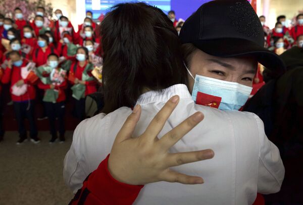 Nữ nhân viên y tế tỉnh Cát Lâm, Trung Quốc tạm biệt các đồng nghiệp tại sân bay quốc tế Thiên Hà, Vũ Hán, Trung Quốc - Sputnik Việt Nam