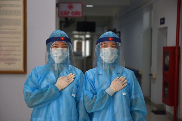 Các nữ nhân viên y tế mặc quần áo bảo hộ tại trung tâm xét nghiệm coronavirus dã chiến ở Hà Nội, Việt Nam - Sputnik Việt Nam