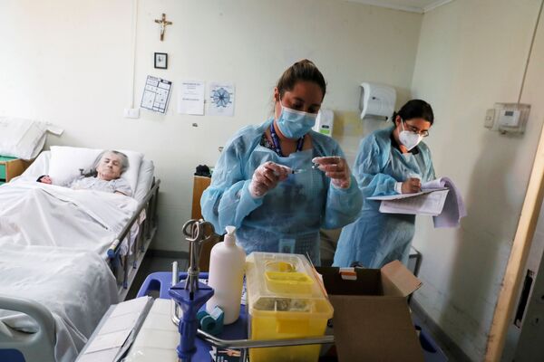 Các nữ nhân viên y tế tại viện dưỡng lão ở Santiago trước khi tiêm vắc xin chống coronavirus cho nữ bệnh nhân lớn tuổi - Sputnik Việt Nam