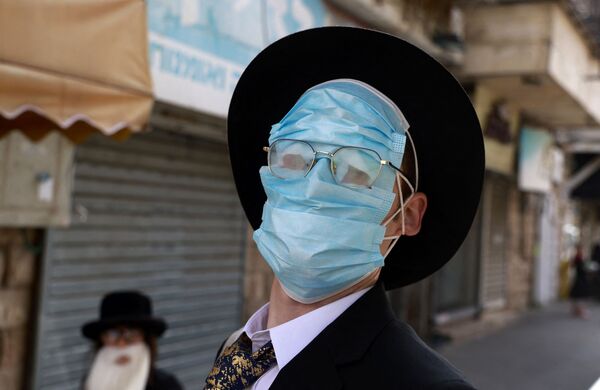 Một người đàn ông đeo khẩu trang bảo vệ trong lễ kỷ niệm Purim ở Jerusalem - Sputnik Việt Nam