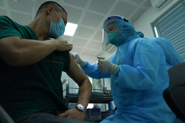 Bệnh nhân đang được tiêm vắc-xin Covid-19 tại Hà Nội - Sputnik Việt Nam