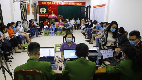 Rất đông người dân ngồi chờ đến lượt làm thủ tục cấp căn cước công dân lưu động tại trụ sở Công an phường Đồng Tâm (ảnh chụp lúc 22h tối 10/3/2021) - Sputnik Việt Nam