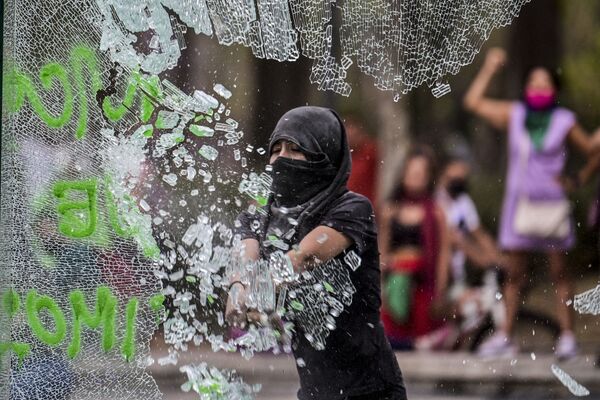 Người phụ nữ đập vỡ kính trong cuộc biểu tình nhân Ngày Quốc tế Phụ nữ ở Mexico City, Mexico - Sputnik Việt Nam