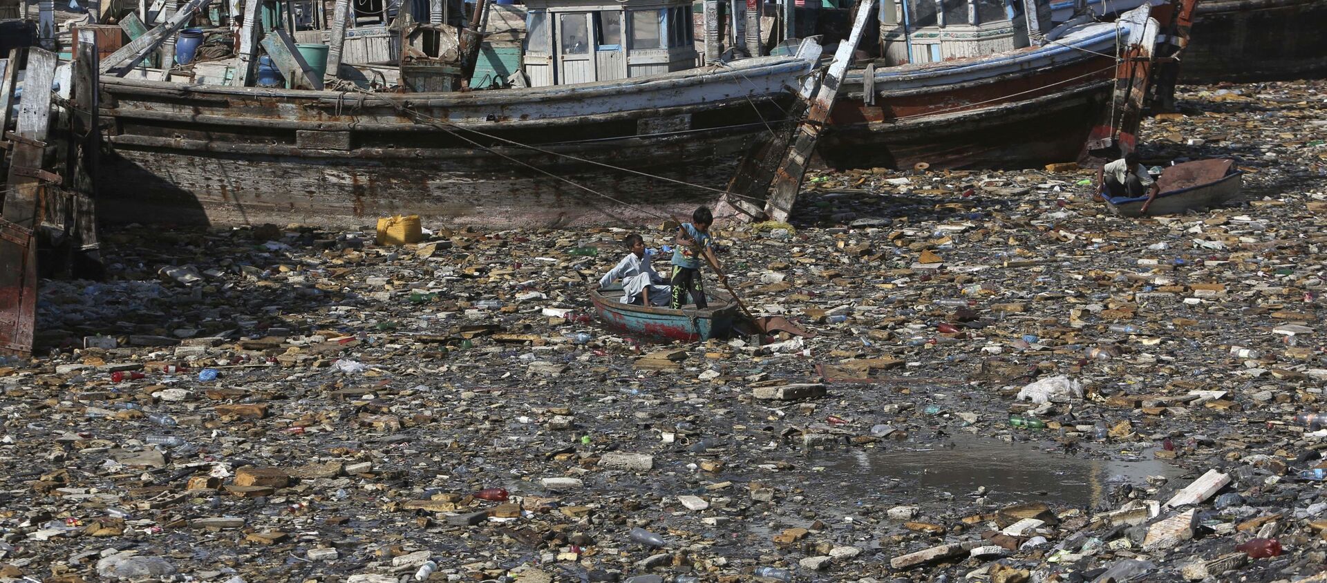 Trẻ em thu gom rác tái chế ở bến cảng bị ô nhiễm ở Karachi, Pakistan - Sputnik Việt Nam, 1920, 17.03.2021