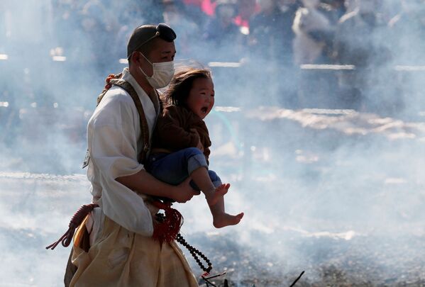 Nhà sư Phật giáo bế một đứa trẻ đang khóc trong lễ hội đi bộ trên lửa ở Nhật Bản - Sputnik Việt Nam