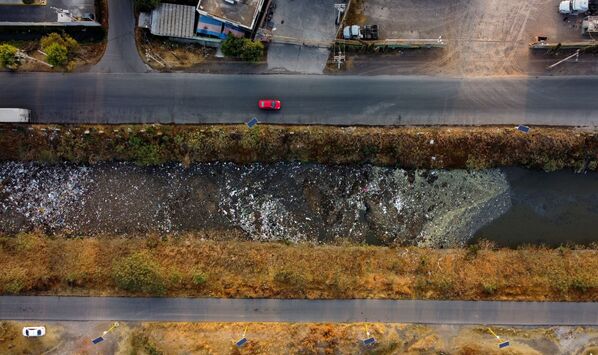 Dòng ô tô di chuyển gần kênh Interceptor Poniente, bị ô nhiễm nặng vì nước thải và rác ở Cuautitlán, Mexico - Sputnik Việt Nam