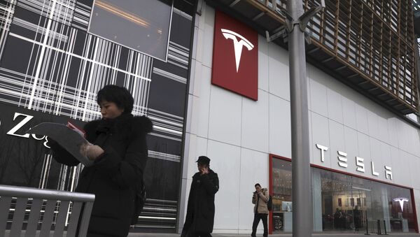 Residents walk past a Tesla store in Beijing - Sputnik Việt Nam