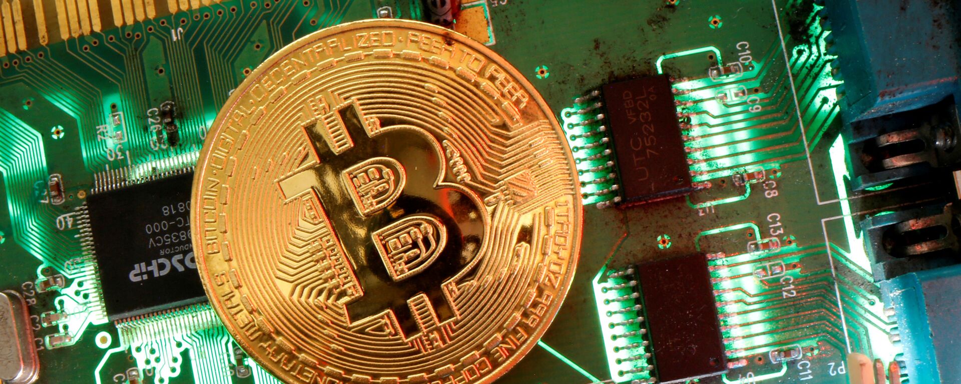 Đại diện của tiền ảo Bitcoin được nhìn thấy trên bo mạch chủ trong hình minh họa này được chụp vào ngày 24 tháng 4 năm 2020 - Sputnik Việt Nam, 1920, 30.03.2021
