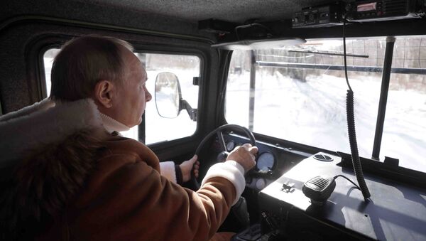 Tổng thống Nga Vladimir Putin lái xe địa hình khi đi dạo trong rừng taiga. - Sputnik Việt Nam
