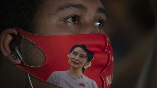 Một công dân Myanmar sống ở Thái Lan đeo khẩu trang có hình nhà lãnh đạo Myanmar Aung San Suu Kyi trong cuộc biểu tình trước Đại sứ quán Myanmar ở Bangkok, Thái Lan, thứ Năm, ngày 4 tháng 2 năm 2021. Quân đội tuyên bố hôm thứ Hai rằng họ sẽ nắm quyền trong một năm, cáo buộc chính phủ của bà Suu Kyi không điều tra các cáo buộc gian lận cử tri trong các cuộc bầu cử gần đây. Đảng của bà Suu Kyi đã quét sạch cuộc bỏ phiếu đó và đảng được quân đội hậu thuẫn đã làm rất kém. Ủy ban Bầu cử tiểu bang đã bác bỏ các cáo buộc. - Sputnik Việt Nam
