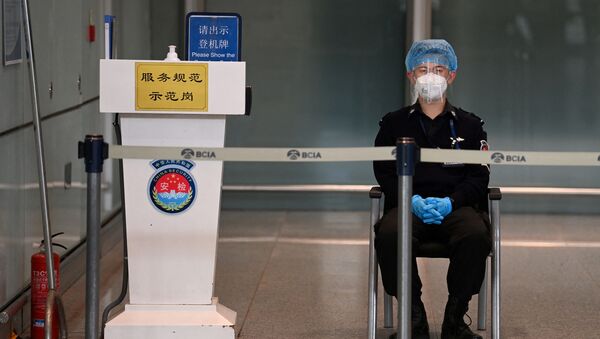 Một nhân viên đeo khẩu trang ở sân bay Bắc Kinh. - Sputnik Việt Nam
