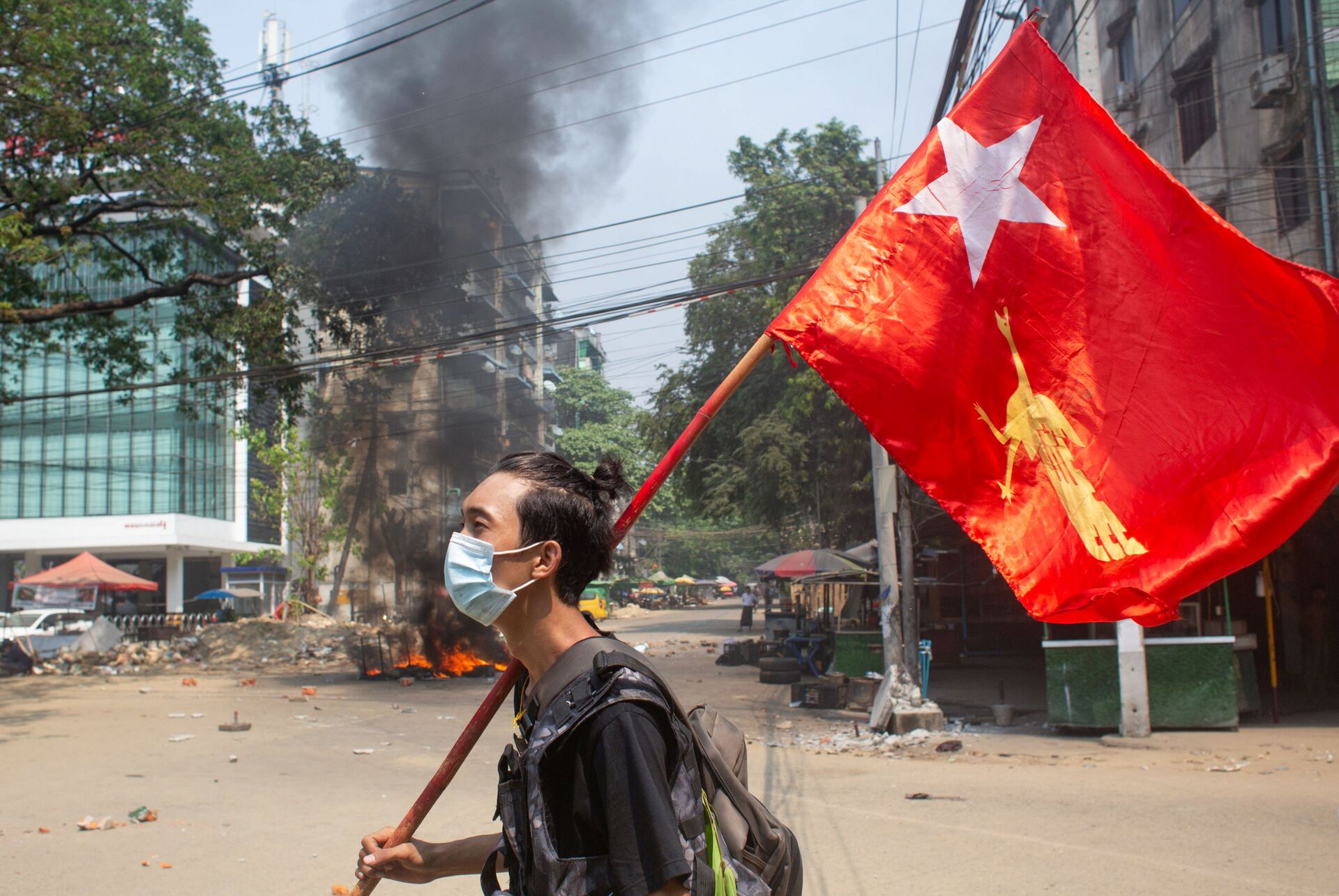 Một người đàn ông cầm cờ của Liên đoàn Quốc gia vì Dân chủ trong cuộc biểu tình phản đối đảo chính quân sự ở Yangon, Myanmar. - Sputnik Việt Nam, 1920, 18.04.2022