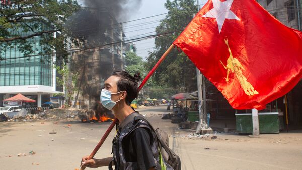 Một người đàn ông cầm cờ của Liên đoàn Quốc gia vì Dân chủ trong cuộc biểu tình phản đối đảo chính quân sự ở Yangon, Myanmar. - Sputnik Việt Nam