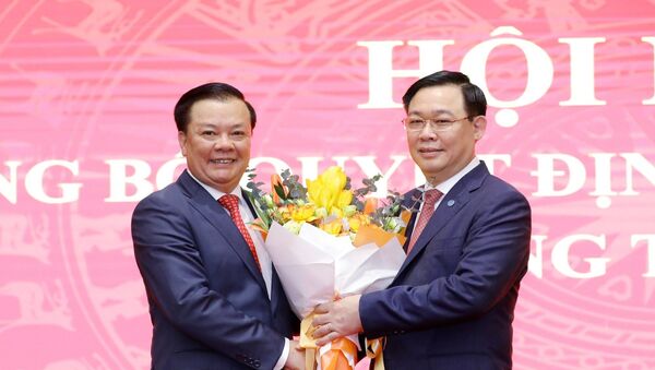 Chủ tịch Quốc hội Vương Đình Huệ tặng hoa chúc mừng tân Bí thư Thành ủy Hà Nội Đinh Tiến Dũng. - Sputnik Việt Nam