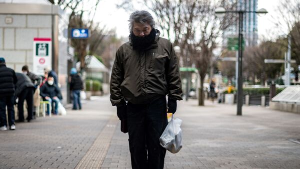Một người đàn ông thất nghiệp đang cầm đồ ăn miễn phí từ Trung tâm Moyai Support Center for Independent Living ở Nhật Bản. - Sputnik Việt Nam