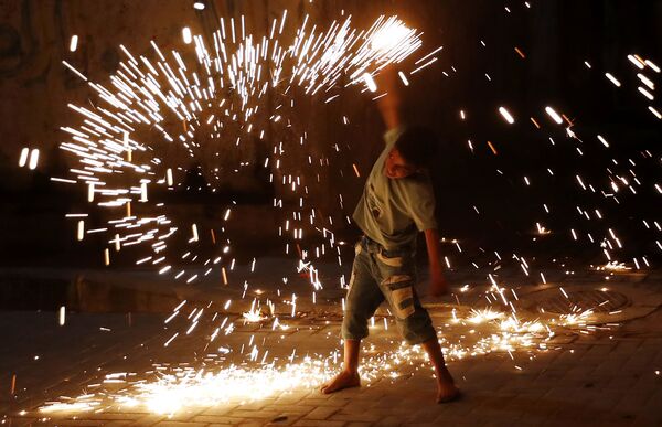 Cậu bé chơi với pháo hoa trong lễ kỷ niệm tháng Ramadan ở thành phố Gaza - Sputnik Việt Nam