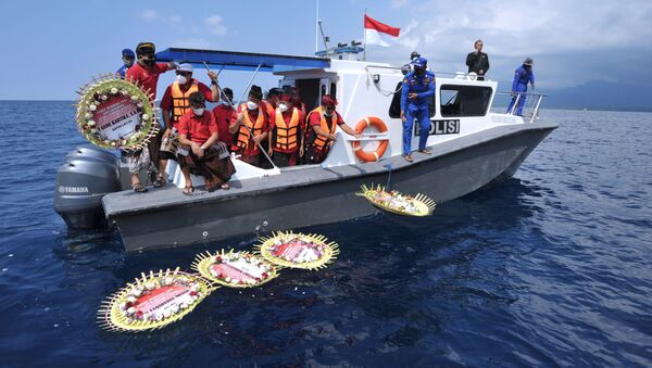  Mọi người từ trên tàu ném hoa và cánh hoa có đề tên các thành viên thủy thủ đoàn tàu ngầm bị chìm KRI Nanggala-402, Indonesia. - Sputnik Việt Nam