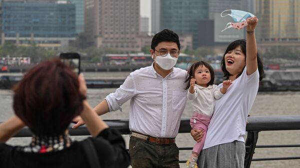 Một gia đình chụp ảnh trên bờ kè ở Thượng Hải ngày 1/5 - Sputnik Việt Nam
