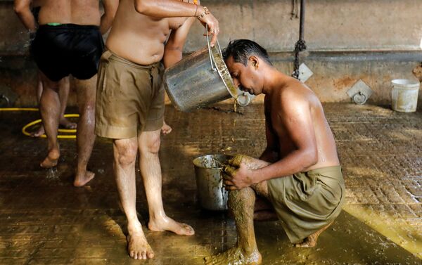 Công nhân Ấn Độ Uddhav Bhatia bôi phân bò lên cơ thể để tăng cường khả năng miễn dịch và sức đề kháng chống coronavirus. - Sputnik Việt Nam