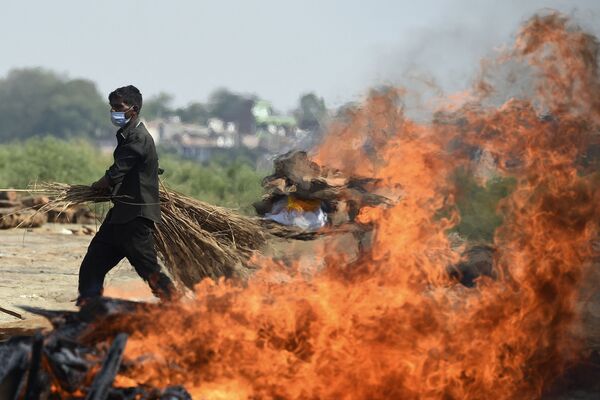 Một công nhân đi qua bãi hỏa táng, Ấn Độ - Sputnik Việt Nam