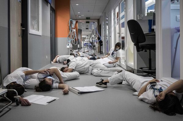 Vào Ngày Quốc tế Điều dưỡng, các y tá nằm nghỉ ngay trên hành lang trong khoa cấp cứu của bệnh viện Mont Legia ở thành phố Liege, Bỉ - Sputnik Việt Nam
